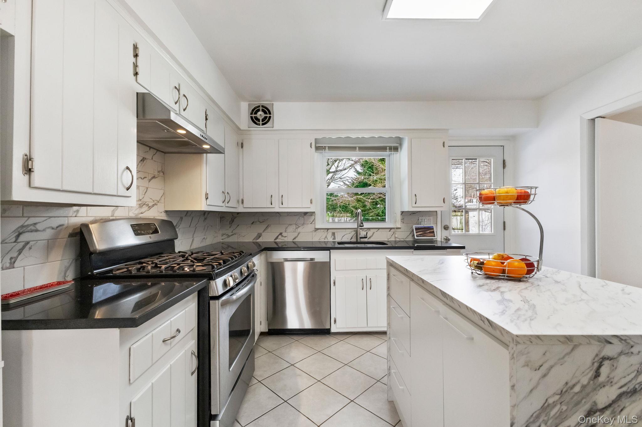 15 Meadow Place Rye, NY 10580 - Photo 7 of 39 Kitchen with white cabinets, black granite countertops, stainless steel appliances and ceramic tile floor.