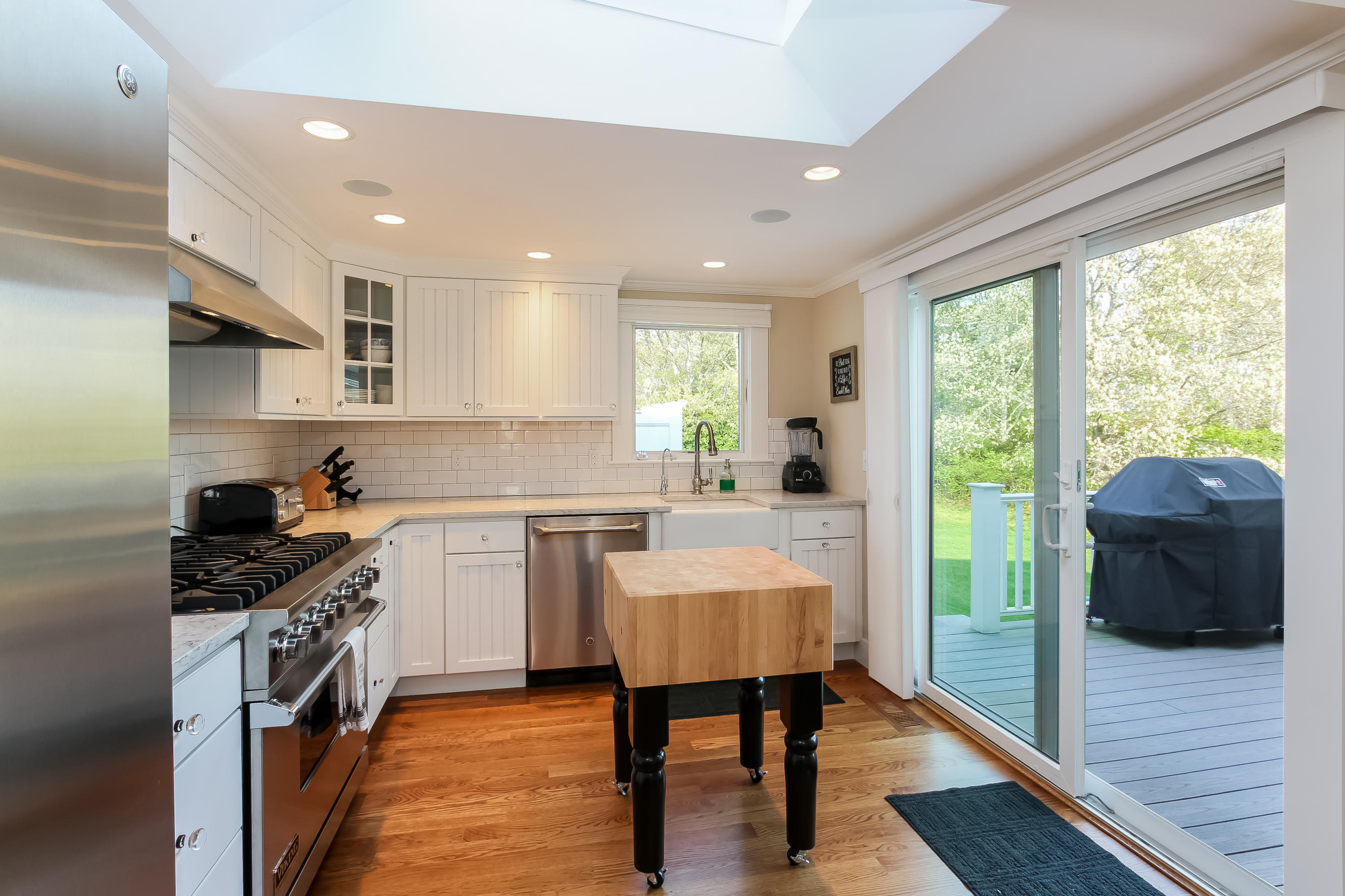 15 Colonial Way Harwich Port, MA 02646 - Photo 12 of 28 a kitchen with a sink a counter top space a stove a refrigerator cabinets and a large window