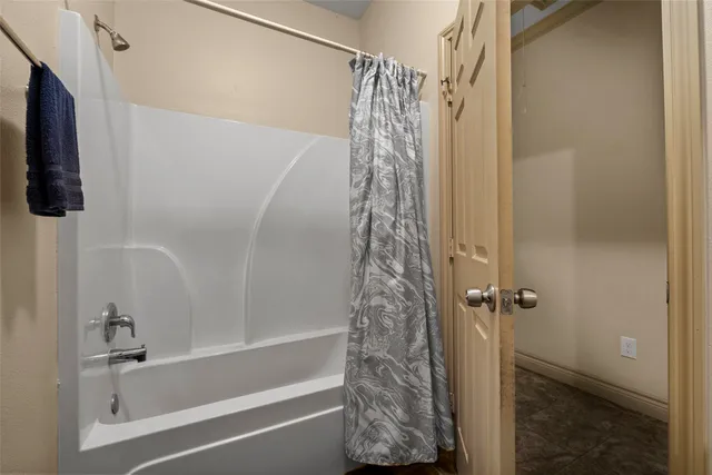 a bathroom with a shower curtain and a window