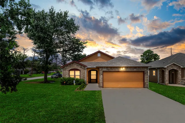 a front view of a house with a garden and yard