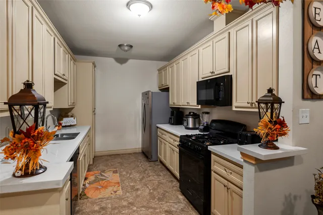 a kitchen with stainless steel appliances a stove a sink a microwave and cabinets