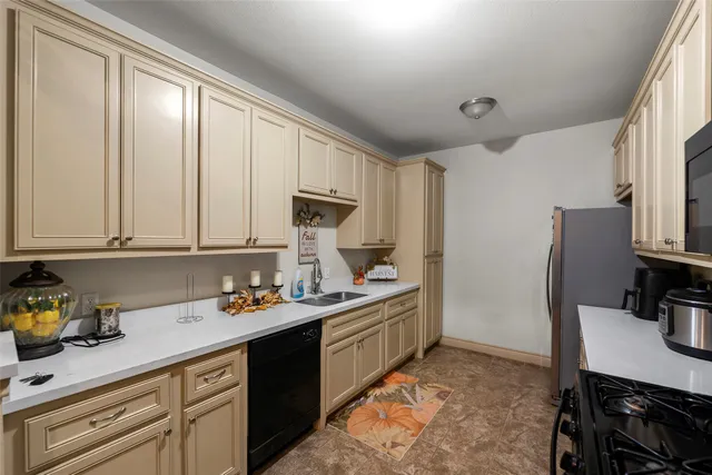 a kitchen with stainless steel appliances granite countertop a sink refrigerator and cabinets