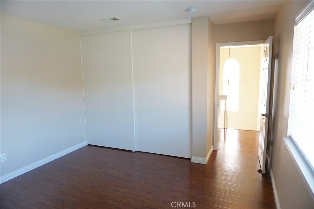 19584 Shadow Glen Circle Porter Ranch, CA 91326 - Photo 36 of 72 a view of an empty room with wooden floor and a window