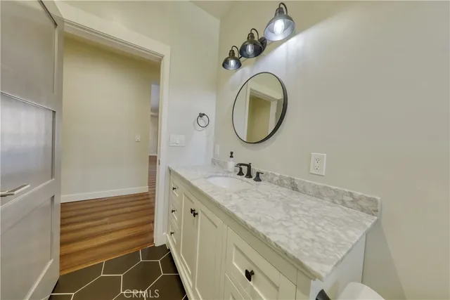 a spacious bathroom with a granite countertop toilet sink and mirror