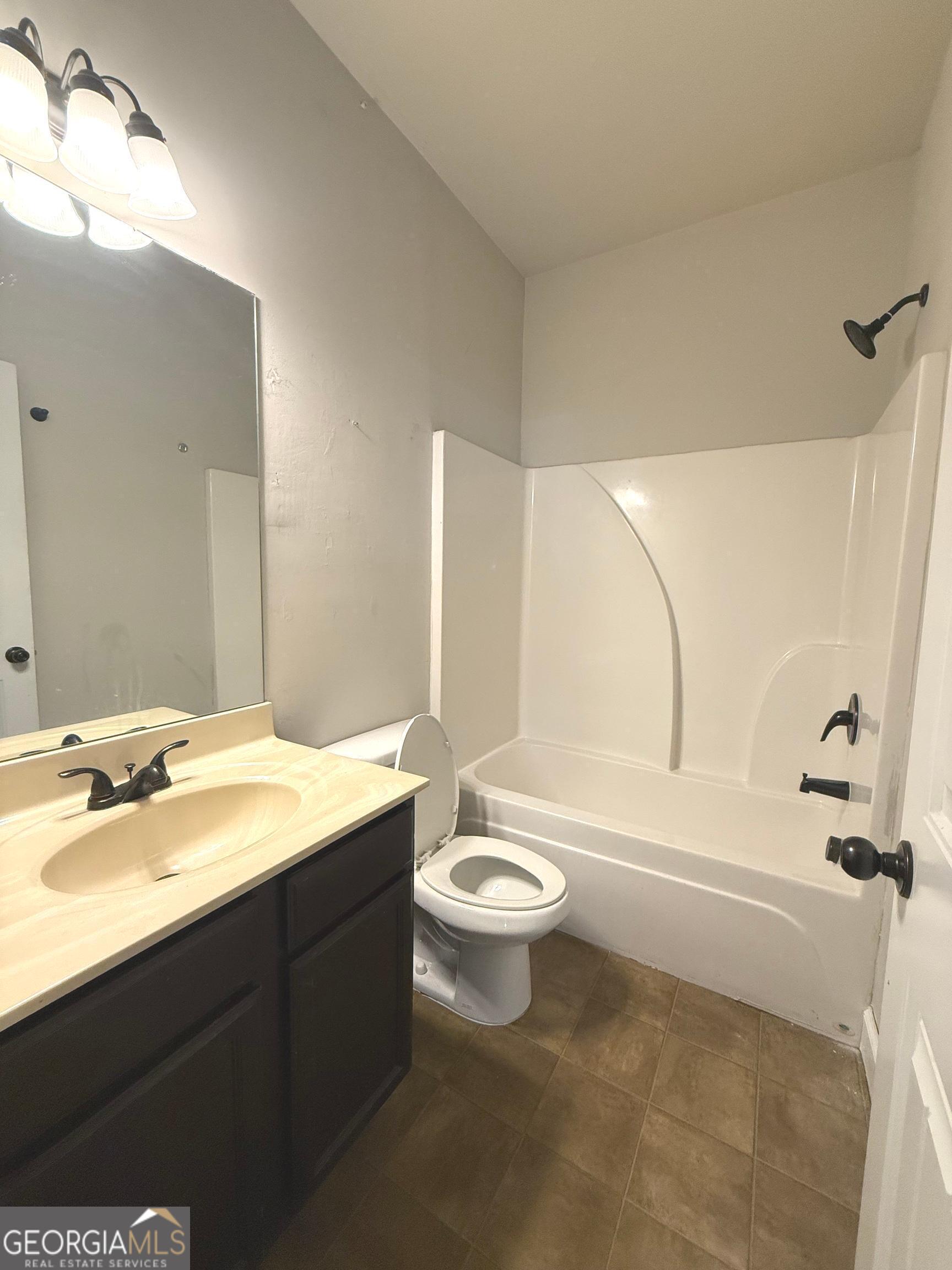 9159 Dover Street Lithia Springs, GA 30122 - Photo 7 of 17 a bathroom with a double vanity sink toilet mirror and bathtub