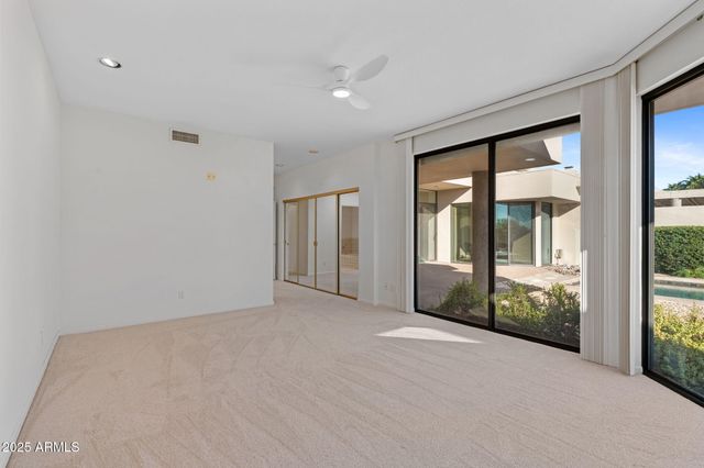 a view of an empty room with sliding glass door and windows