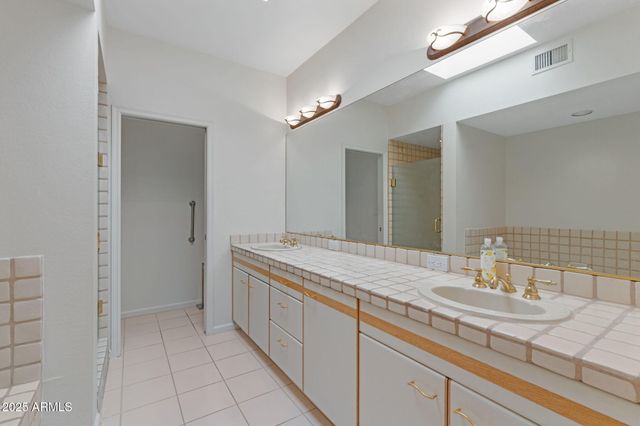 a bathroom with a granite countertop sink a mirror and a bathtub