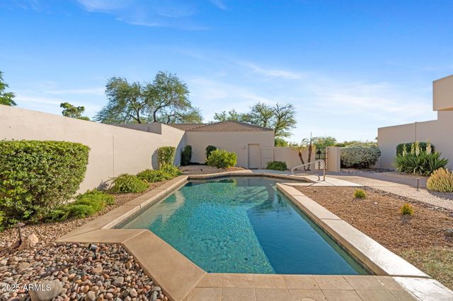 a view of a white house with a swimming pool and a yard