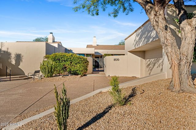 a front view of a house with a yard and potted plants