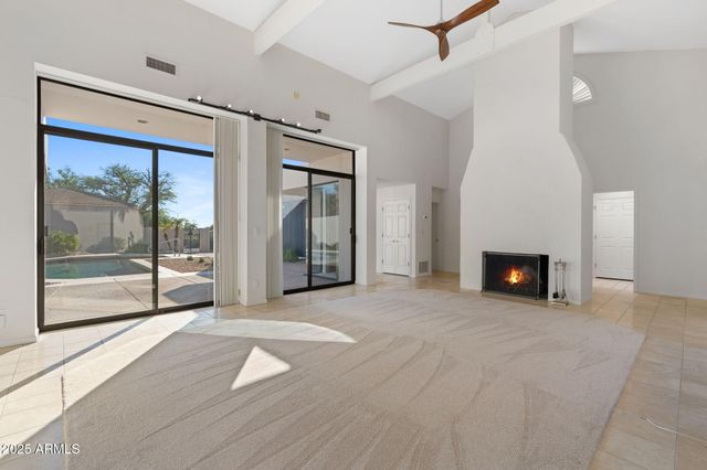 a view of an empty room with a fireplace and a window