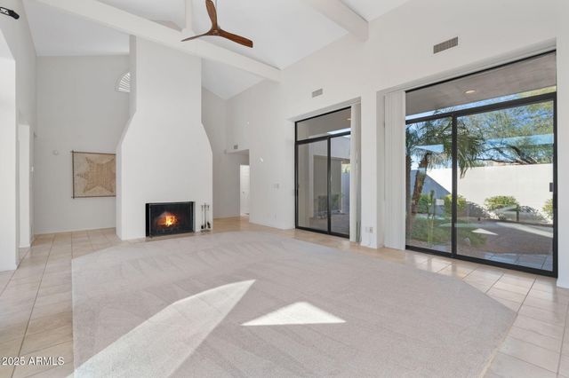 a view of an empty room with windows and a fireplace