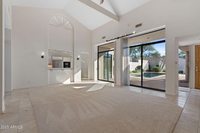 a view of an empty room with a fireplace and a window