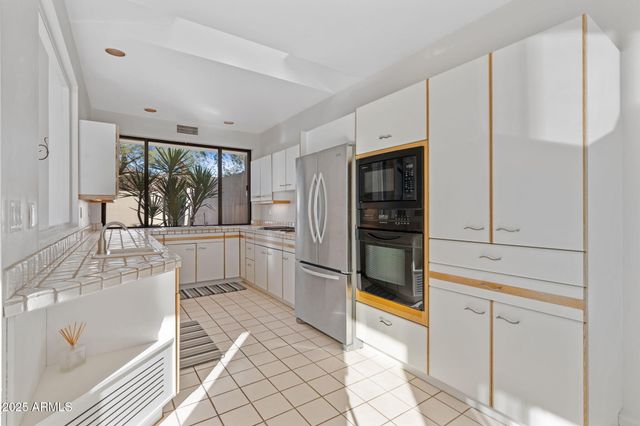 a kitchen with white cabinets and stainless steel appliances