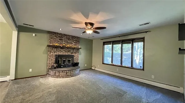 an empty room with fireplace and windows