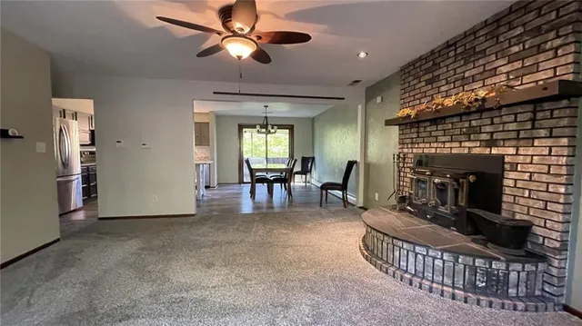 a living room with furniture a fireplace and a ceiling fan