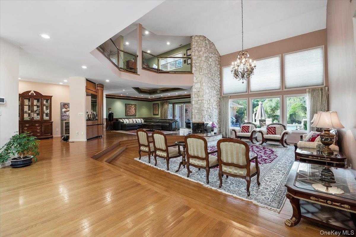 12 Ridge Court Glen Head, NY 11545 - Photo 4 of 46 Dining room featuring light wood finished floors, a towering ceiling, recessed lighting, and a chandelier