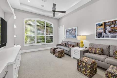 a view of a dining room with furniture a chandelier and large windows