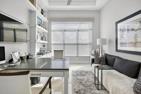 a living room with furniture and floor to ceiling windows