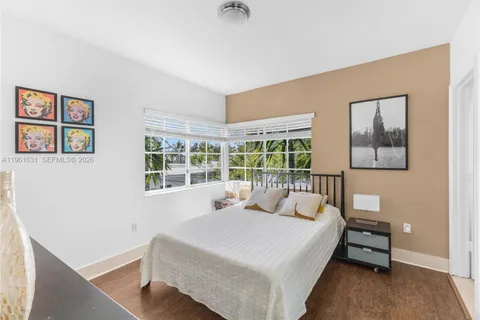 a bedroom with a bed and a large window