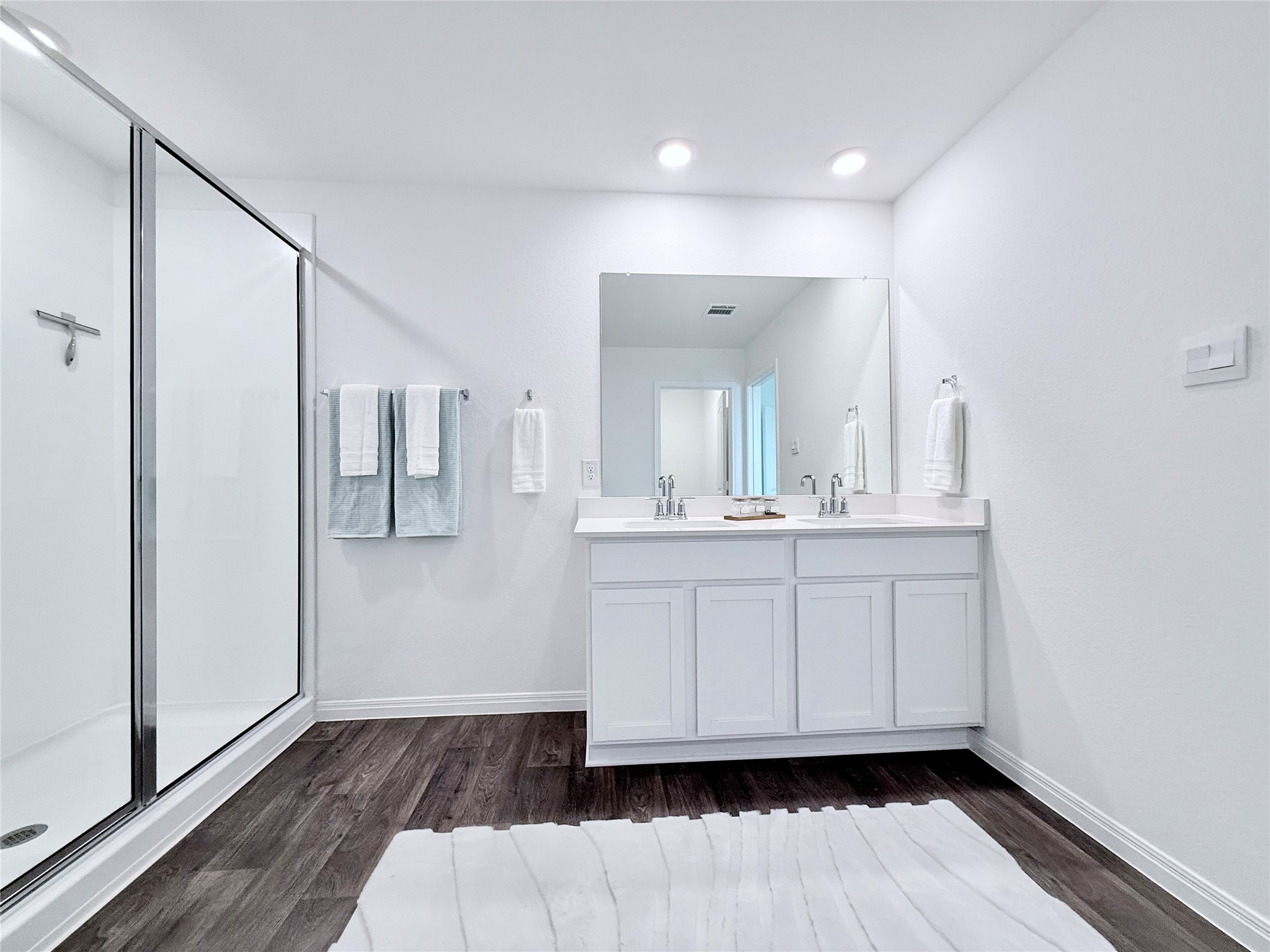 598 Gladiola Loop Kyle, TX 78640 - Photo 22 of 33 Bathroom with double vanity, a shower stall, and dark wood-style flooring