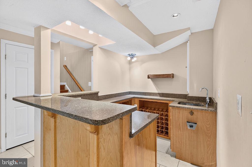 8471 Great Lake Lane Springfield, VA 22153 - Photo 33 of 65 a view of kitchen island with a sink and wooden floor