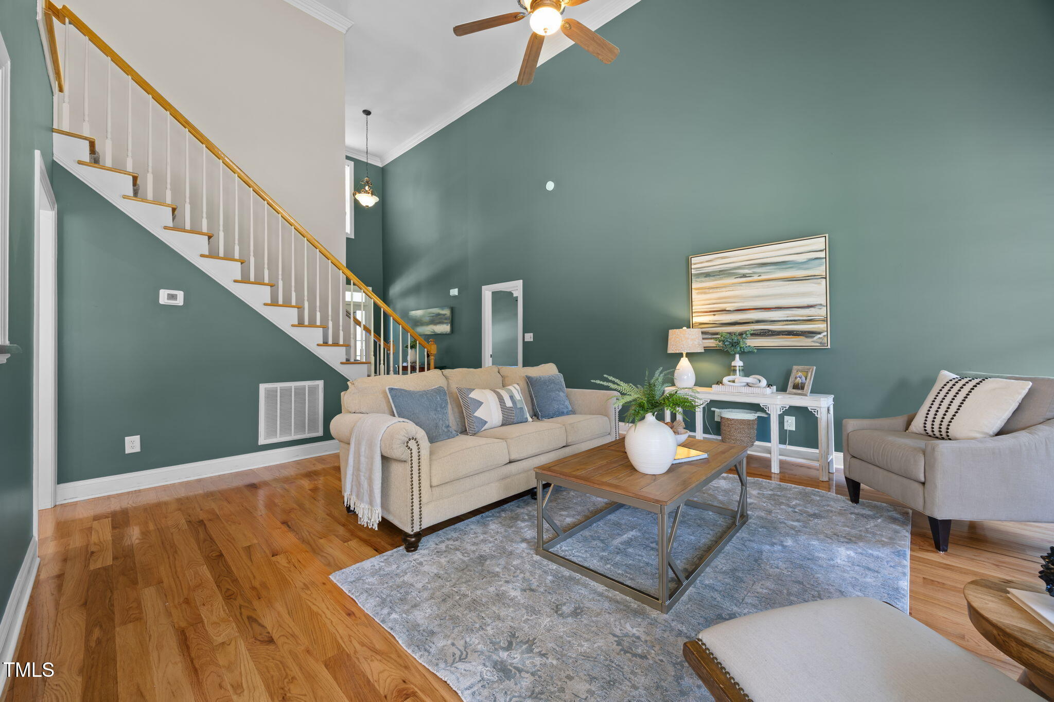 6313 Southern Charm Lane Raleigh, NC 27603 - Photo 13 of 38 a living room with couches and a dining table with wooden floor