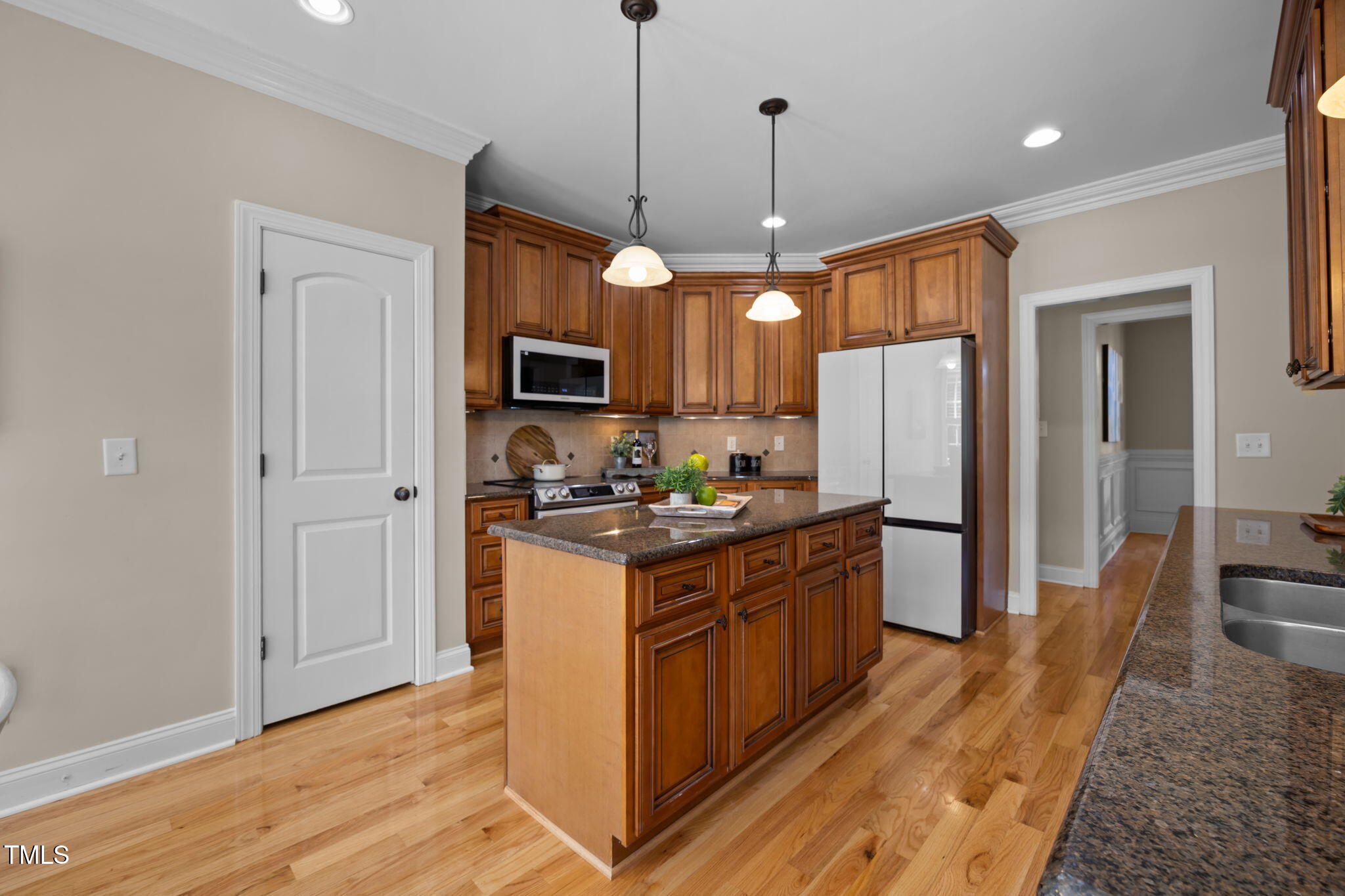 6313 Southern Charm Lane Raleigh, NC 27603 - Photo 15 of 38 a kitchen with stainless steel appliances granite countertop a refrigerator a stove a sink and a wooden floor