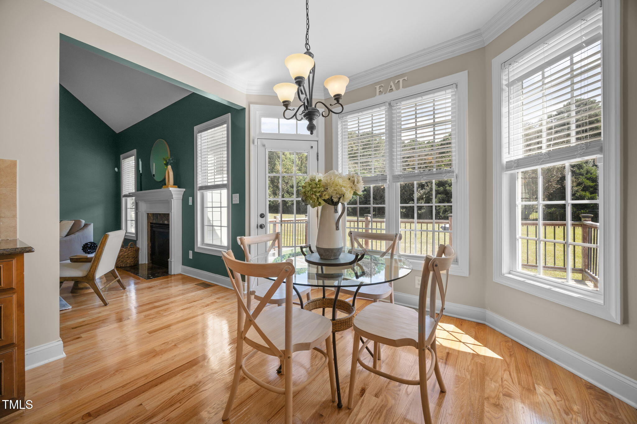 6313 Southern Charm Lane Raleigh, NC 27603 - Photo 17 of 38 a dining room with wooden floor a chandelier a glass table and chairs