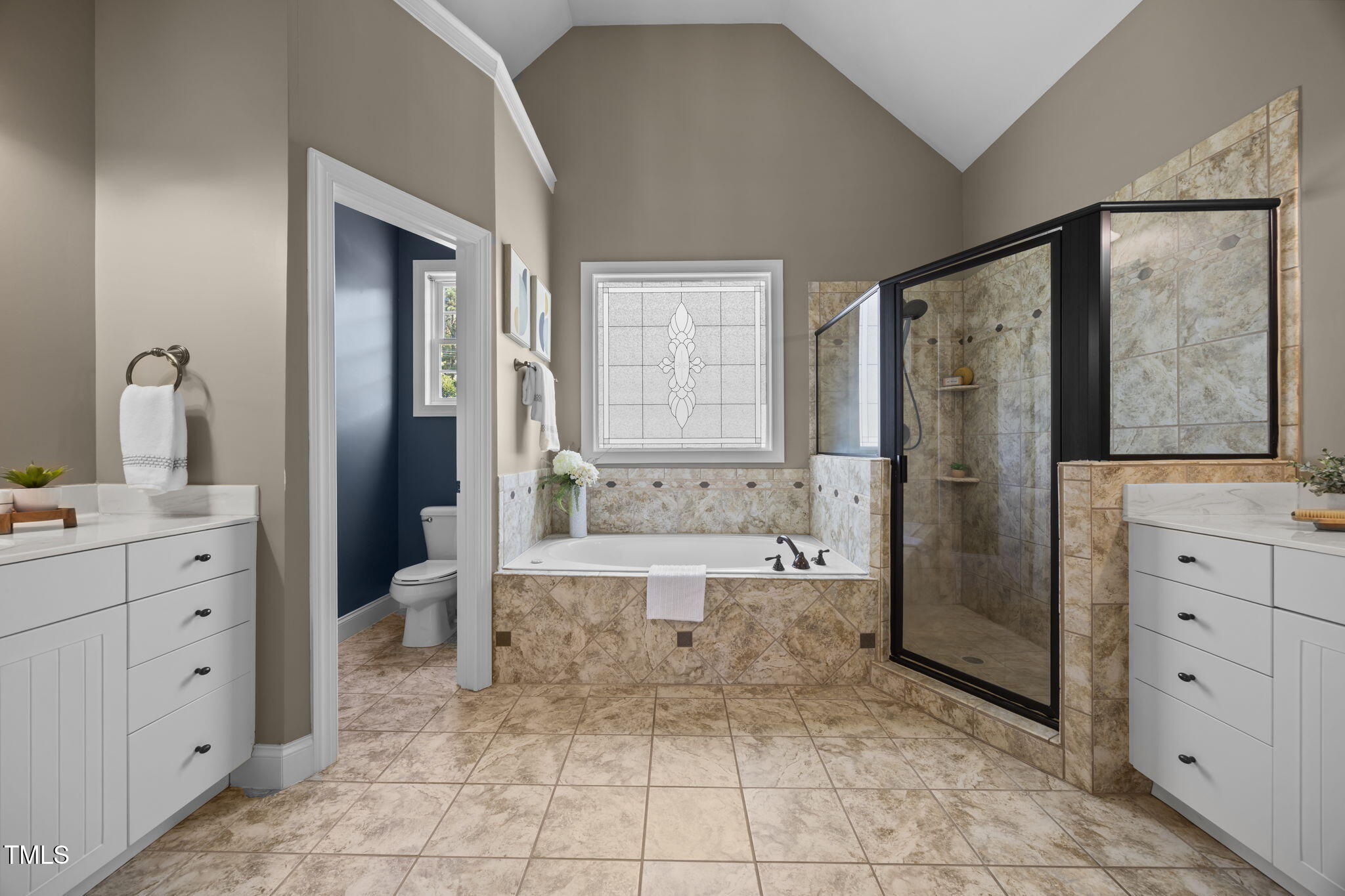 6313 Southern Charm Lane Raleigh, NC 27603 - Photo 21 of 38 a spacious bathroom with a double vanity sink a mirror and a bathtub