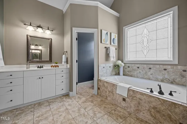 a bathroom with a tub sink and mirror