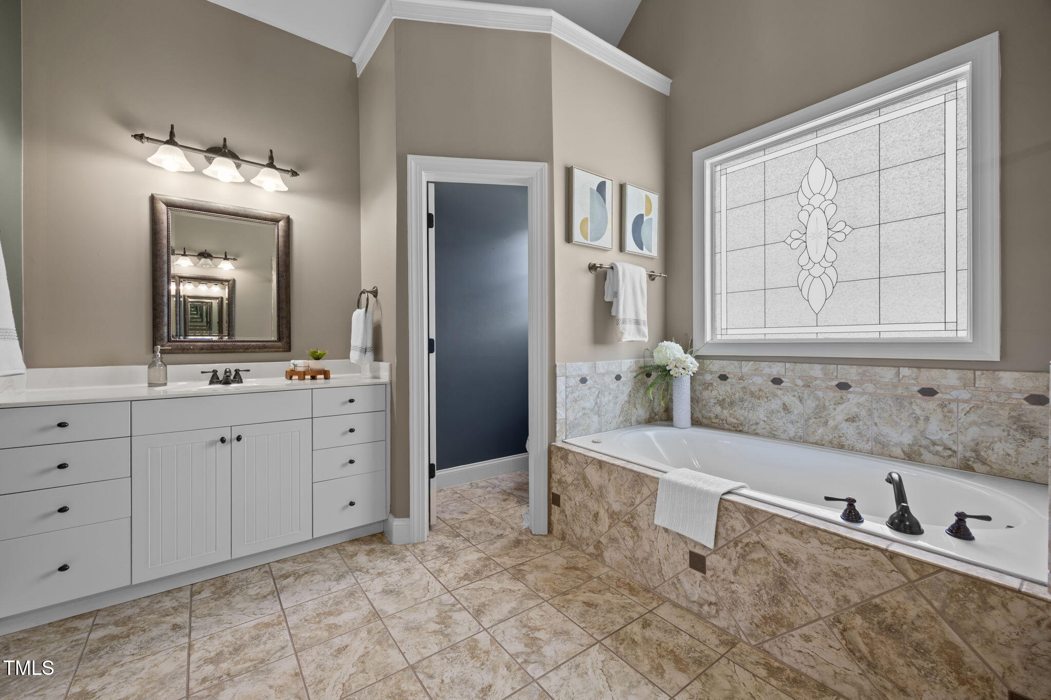 6313 Southern Charm Lane Raleigh, NC 27603 - Photo 22 of 38 a bathroom with a tub sink and mirror