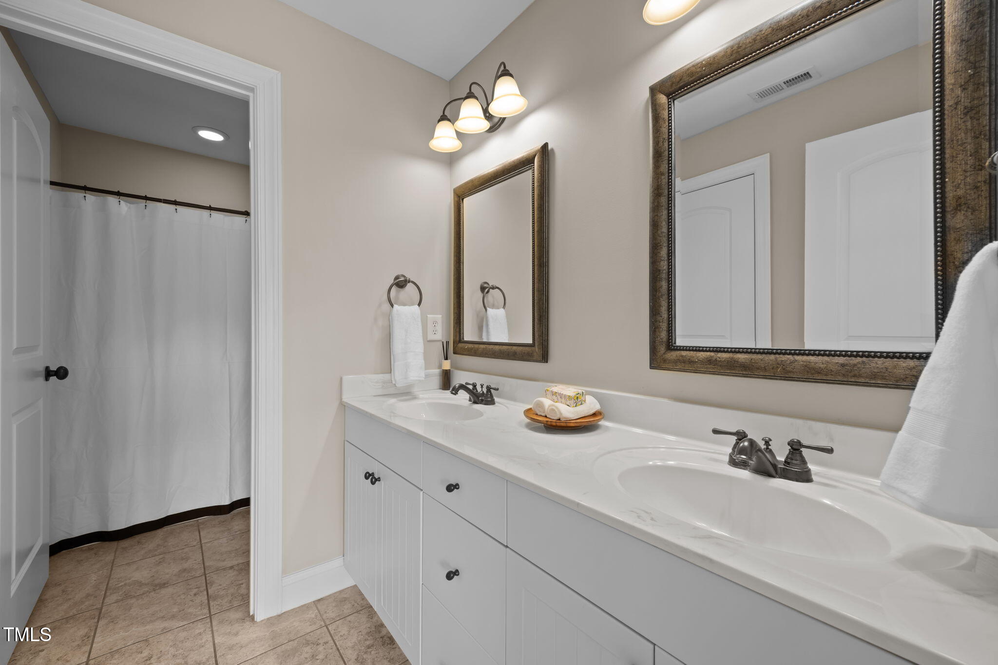 6313 Southern Charm Lane Raleigh, NC 27603 - Photo 29 of 38 a bathroom with double vanity sinks and a mirror