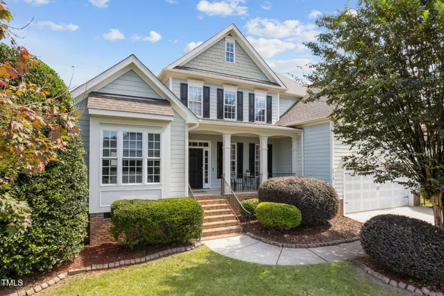 a view of a house with a yard and potted plants