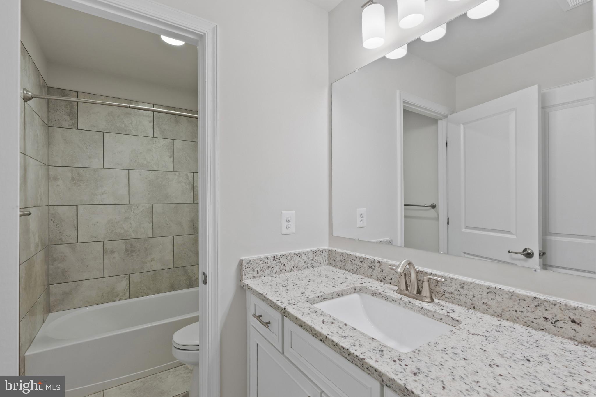 703 Perception Way Aberdeen, MD 21001 - Photo 29 of 42 a bathroom with a granite countertop sink a toilet and shower