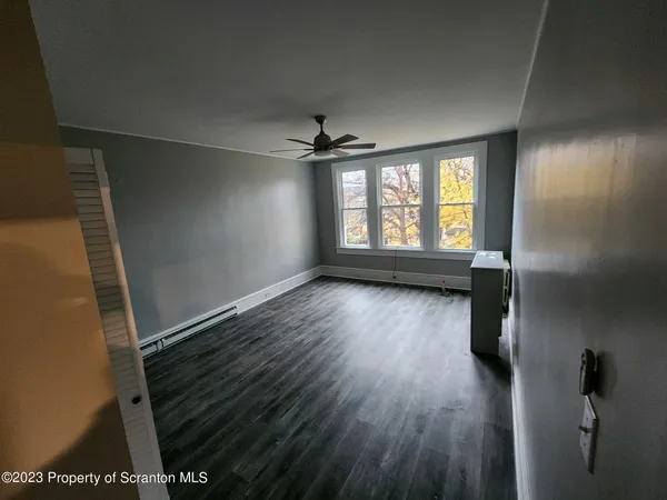 wooden floor in an empty room with a window