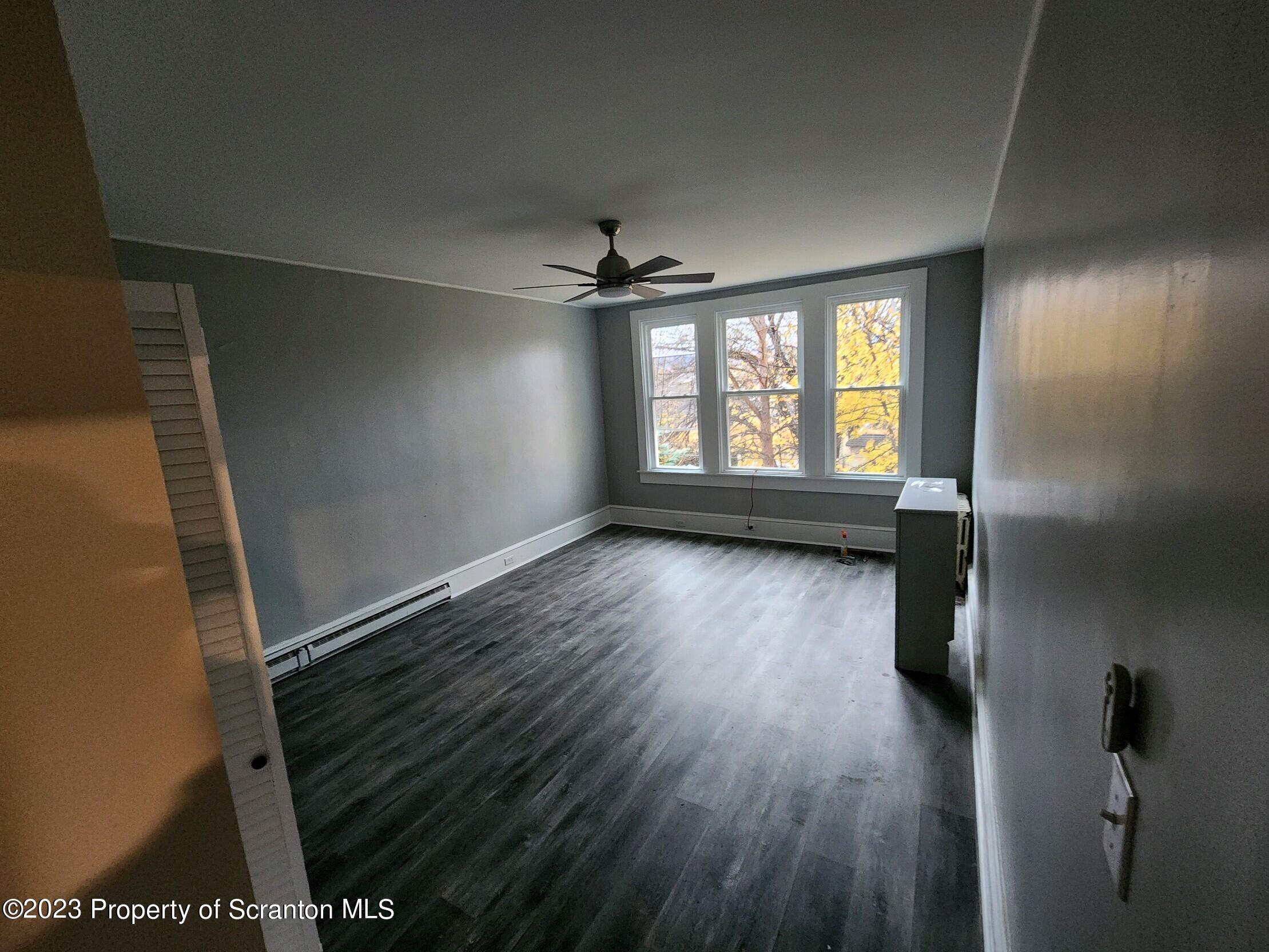 817 Monroe Avenue, Unit 1 Scranton, PA 18510 - Photo 5 of 8 wooden floor in an empty room with a window