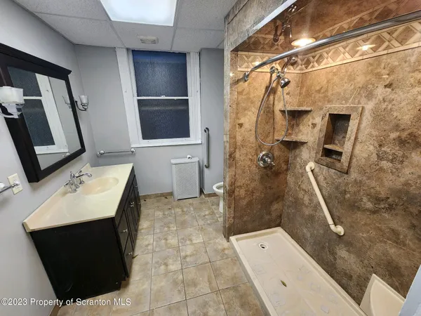 a bathroom with a sink a toilet and shower