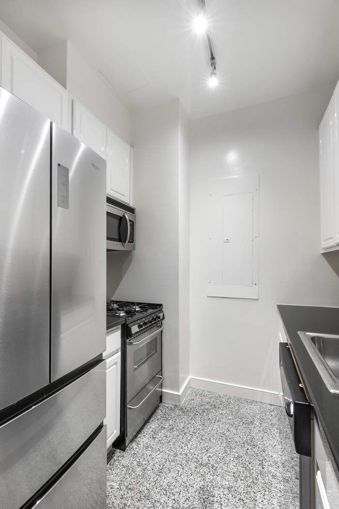 120 East 87th Street, Unit R14K Manhattan, NY 10128 - Photo 8 of 14 a kitchen with stainless steel appliances granite countertop a refrigerator and a stove