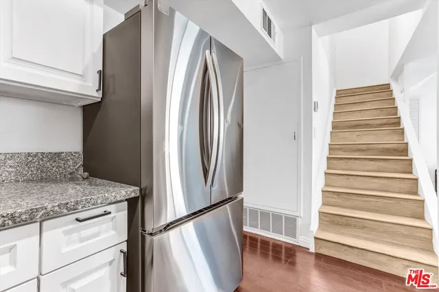 a kitchen with stainless steel appliances granite countertop a refrigerator and a sink