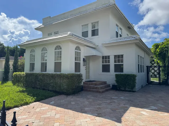 an empty room with windows fireplace and wooden floor