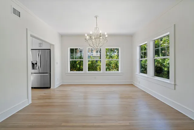 an empty room with wooden floor and window