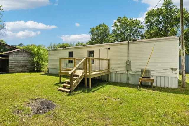 a view of a house with a backyard and a wooden bench