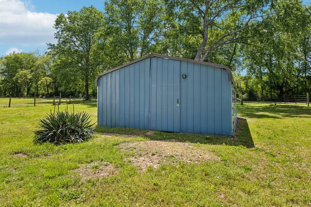 a view of backyard with large trees and plants