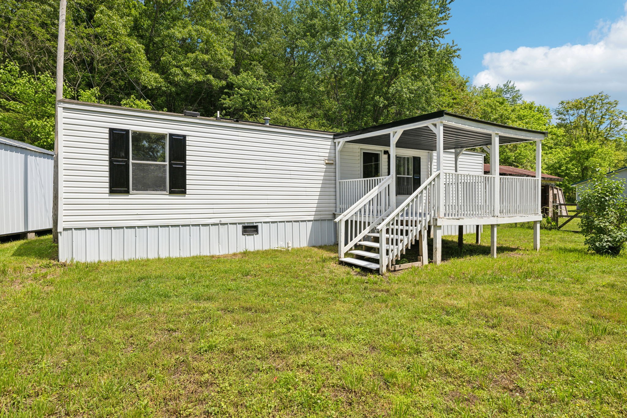 161 Longbranch Road Hohenwald, TN 38462 - Photo 3 of 28 a view of a house with a yard and deck