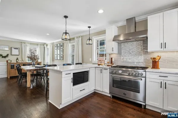 a kitchen with a stove and a wooden floor