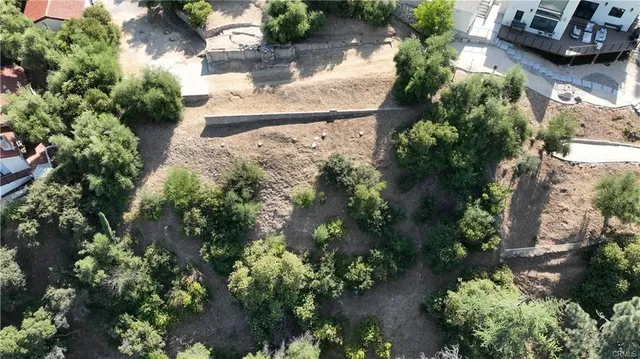 an aerial view of residential house with outdoor space and trees all around