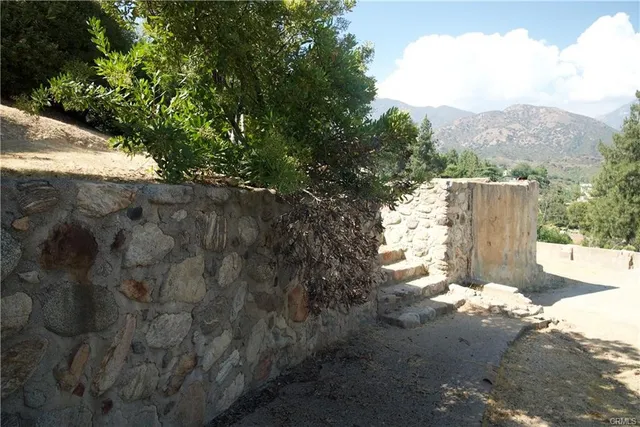 a view of a yard with wooden fence