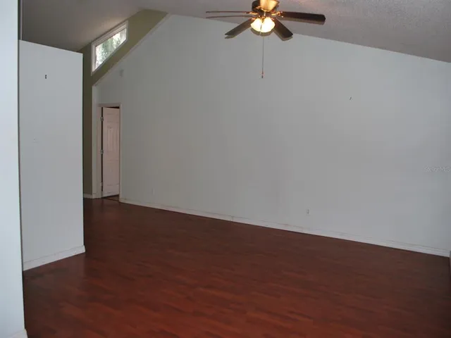 a view of a room with wooden floor and fan