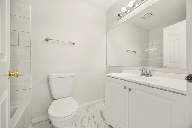 a bathroom with a toilet a sink and mirror