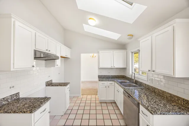a large kitchen with stainless steel appliances granite countertop a sink stove and cabinets